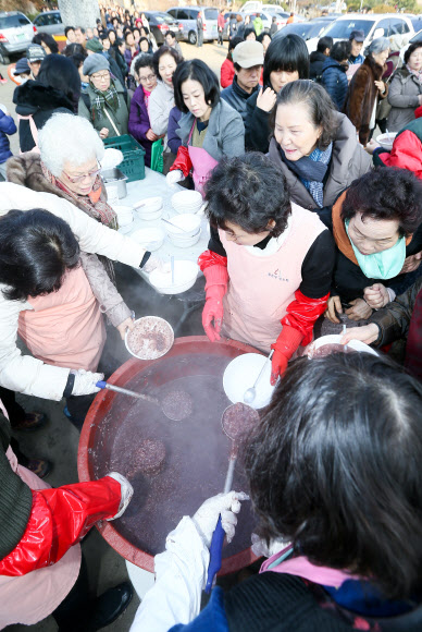 22일 서울 강남구 삼성동 봉은사에서 동지 팥죽 행사가 열려 시민들에게 팥죽을 전달하고 있다. 연합뉴스