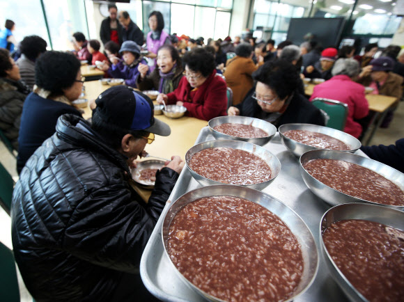 22일 오전 경기도 수원시 권선구 서호노인복지관에서 열린 동지(冬至) 팥죽 나누기 행사에서 어르신들이 팥죽을 먹고 있다.  연합뉴스