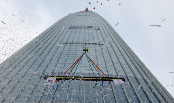 롯데월드타워 상량식이 22일 오후 서울 신천동 롯데월드타워에서 열려 대들보가 123층으로 올라가고 있다.  강성남 선임기자 snk@seoul.co.kr