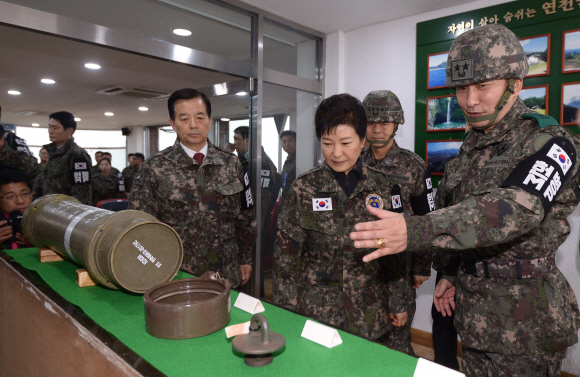 박근혜 대통령이 24일 최전방 안보태세 점검을 위해 경기 연천군 태풍전망대를 방문해 김승겸(오른쪽) 사단장으로부터 포탄 부수 기재 장비에 대한 설명을 듣고 있다. 이 장비들은 지난 8월 20일 북한의 포격 도발 당시 대응사격을 하는 데 쓰였다. 박 대통령 뒤편 왼쪽은 한민구 국방부 장관, 오른쪽은 장준규 육군참모총장. 청와대사진기자단