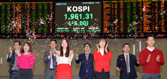 30일 서울 여의도 증권거래소에서 열린 2015년 납회식에서 거래소 직원들이 색종이를 하늘에 날리며 2015년의 증권거래소의 한해를 마치고 있다.  박지환 기자 popocar@seoul.co.kr