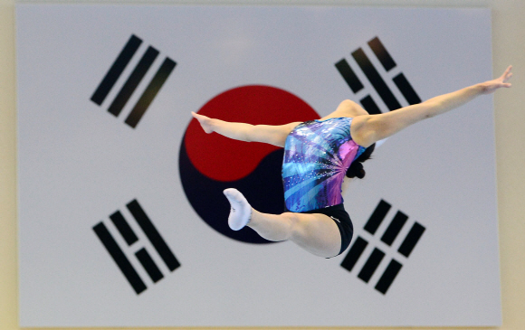 여자 체조 국가대표 선수가 서울 태릉선수촌에서 태극기를 배경으로 화려하게 도약하고 있다.  박윤슬 기자 seul@seoul.co.kr