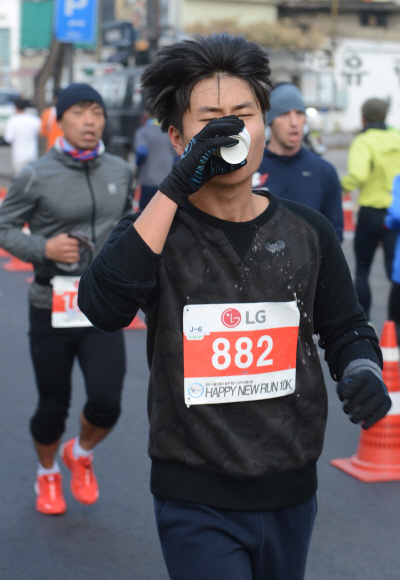 새해 첫날인 1일 오전 본사 주최로 서울 청계광장에서 열린 해피뉴런 마라톤 대회 참가자들이 반환점을 통과하며 음료수를 섭취하고 있다. 안주영 기자 jya@seoul.co.kr