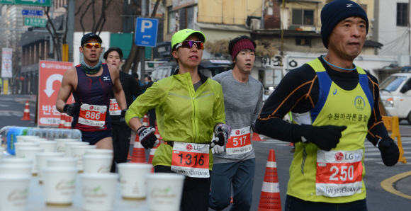 새해 첫날 아침 열린 ‘서울신문 해피 뉴런’ 10㎞ 마라톤 대회 여자부 우승자 이선영(왼쪽 세 번째)씨 등 참가자들이 음료수가 놓여 있는 서울 종로5가 전태일다리 앞 반환점을 힘차게 통과하고 있다. 안주영 기자 jya@seoul.co.kr
