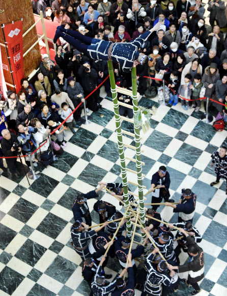 4일(현지시간) 일본 도쿄의 한 백화점에서 새해 기념 이벤트로 일본 전통의상을 입은 남성이 대나무 사다리 위에 올라 중심을 잡는 묘기를 선보여 사람들의 시선을 끌었다. ⓒ AFPBBNews=News1