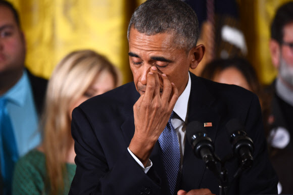 버락 오바마 미국 대통령이 5일(현지시간) 백악관 이스트룸에서 총기규제 행정명령을 발표하던 중 흘러내린 눈물을 닦고 있다. ⓒ AFPBBNews=News1