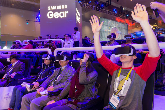 6일(현지시간) 미국 라스베이거스 컨벤션센터에서 개막한 세계 최대 가전쇼 CES 2016의 삼성전자 부스를 찾은 관람객들이 가상현실(VR) 기기인 기어 VR을 통해 롤러코스터인 ‘우든코스터’ 등을 체험하며 즐거워하고 있다.   삼성전자 제공 