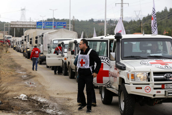 구호물품을 실은 국제적십자사의 트럭들이 11일(현지시간) 기아 위기에 놓인 시리아 남서부 소도시 마다야에 진입하기 위해 줄지어 정차해 있다. 마다야 AFP 연합뉴스