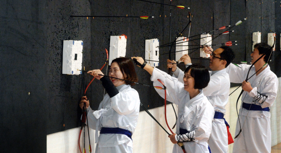 서울 충무아트홀 문화센터에서 운영하는 ‘전통 활쏘기 교실’ 프로그램에 참가한 시민들이 과녁에 맞은 화살을 뽑으며 즐거워하고 있다.