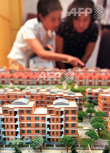 아파트 건설업체의 한 여직원이 아파트 모델 하우스 전시회를 찾아온 손님에게 새로 지을 아파트에 대해 설명하고 있다. 　ⓒ AFPBBNews=News1 　