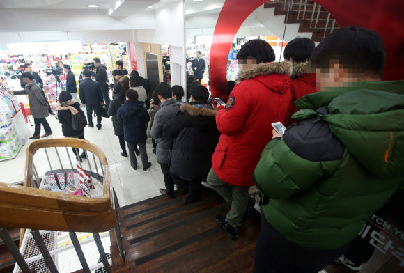 27일 서울 종로구 다이소 종각점에서 자판기로 판매되는 샤오미의 ‘홍미3’를 한 시민이 구입하고 있다. 다이소는 이날 정오부터 ‘홍미3’, ‘홍미노트3’, ‘레노버’, ‘블랙베리’ 등  300대를 각 9만9천원에 판매했다. 다이소 매장 내 폰플러스컴퍼니의 자판기를 통해 유심으로 개통하는 것이 조건이다. 신규가입, 번호이동, 기기변경 모두 가능하다. 그러나 예정된 시간이 지나면서까지 자판기에 오류가 발생해 구입하려는 시민들이 불편을 겪었다. 연합뉴스