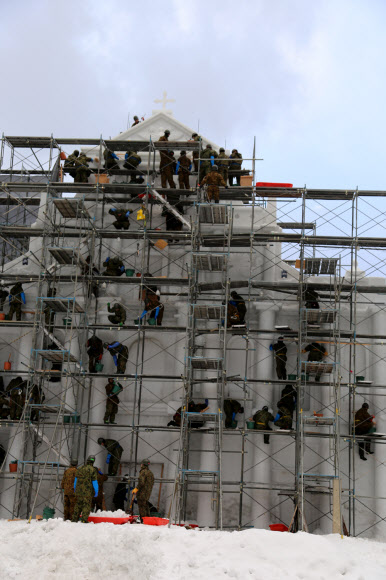 삿포로(札晃) 눈 축제를 앞두고 일본 홋카이도(北海道) 삿포로시 오도리(大通り)에 마련된 행사장에서 27일 육상 자위대원들이 마카오의 세인트 폴 대성당 모양으로 눈 조각상을 만들고 있다.  연합뉴스