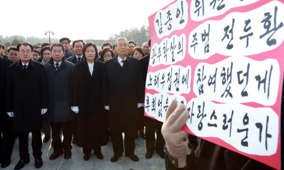 취임 후 첫 지방 일정으로 광주를 찾은 더불어민주당 김종인(앞줄 맨 오른쪽) 비상대책위원장이 31일 광주 북구 운정동 국립 5·18 민주묘지 참배단에 참배하려 하자 5·18 정신실천연합 회원들이 피켓을 들고 항의 시위를 벌이고 있다. 김 위원장 왼쪽은 박영선 비상대책위원.  광주 연합뉴스