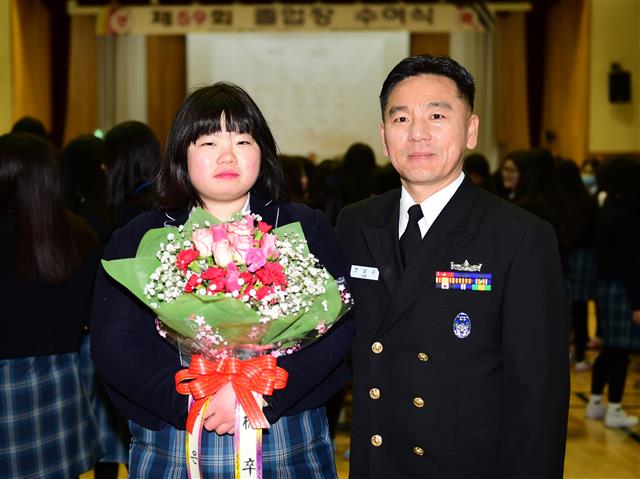 권은별(왼쪽)양이 3일 경남 창원 세화여고 졸업식에서 전영규 해군 군수사령부 주임원사와 기념 촬영을 하고 있다. 해군 제공