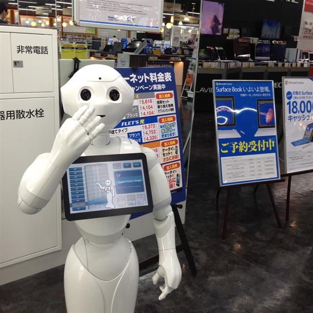 지능형 로봇 페퍼가 3일 일본 도쿄의 가전매장인 콘셉트 라비 입구에서 진열 상품 등에 대해 손가락을 움직여 가며 설명하고 있다.