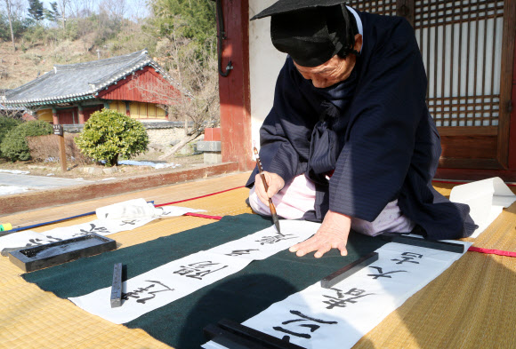 입춘(立春) 4일 오전 전북 전주시 완산구 전주향교에서 김춘원 전교(가운데)가 ‘입춘대길(立春大吉)’과 ‘건양다경(建陽多慶)’ 등 봄을 맞이하는 입춘방을 적고 있다.  연합뉴스