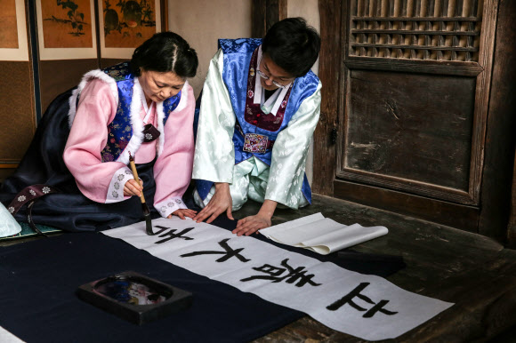 입춘인 4일 서울 국립민속박물관에서 직원들이 전통한옥 오촌댁에서 입춘첩을 쓰고 있다. 입춘은 24절기 중 첫째 절기로 봄의 시작이자 봄을 맞이하는 날이다. 입춘에는 한해 일이 잘 되기를 기원하는 입춘첩을 써서 대문이나 문설주에 붙인다.  연합뉴스