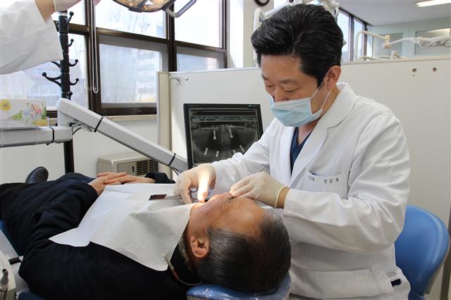 권긍록 경희대 치과병원 교수가 임플란트 시술을 한 환자의 치아를 점검하고 있다. 경희대의료원 제공