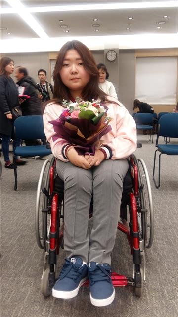 김명지양이 16일 서울 연세대 강남세브란스병원에서 열린 ‘한국의 호킹들, 축하합니다’ 행사에서 꽃다발을 들고 휠체어에 앉아 있다. 
