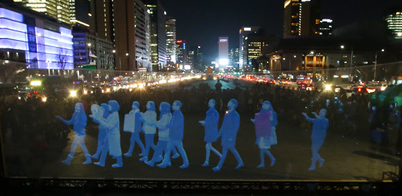국제앰네스티 한국지부가 24일 서울 종로구 광화문광장에서 홀로그램 영상을 이용한 ‘유령집회’를 하고 있다.  연합뉴스