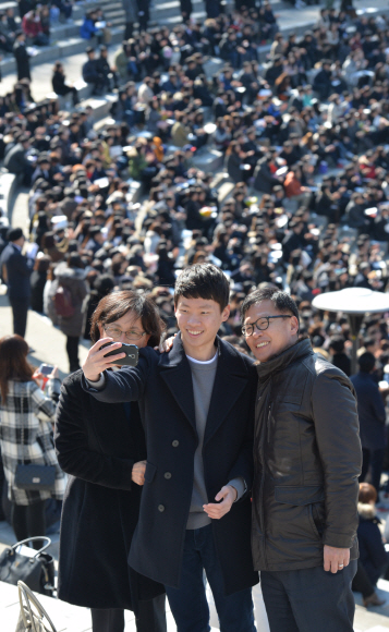 26일 서울 서대문구 신촌동 연세대학교 노천극장에서 열린 입학식에 참석한 한 신입생이 부모님과 함께 스마트폰으로 셀카를 찍으며 입학식의 추억을 사진으로 남기고 있다. 2016. 2. 26 손형준 기자 boltagoo@seoul.co.kr