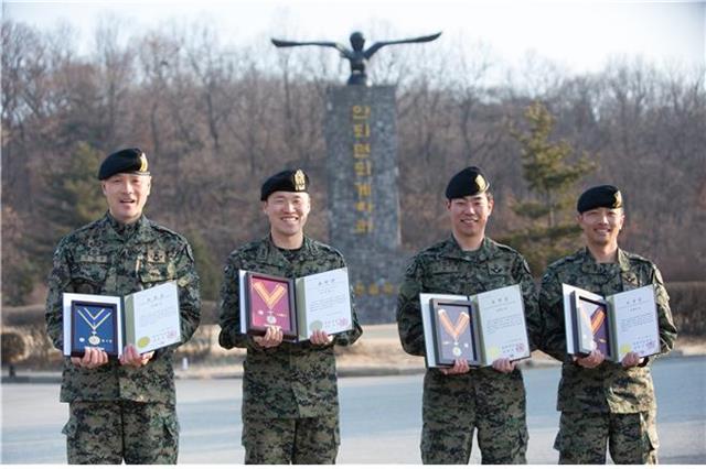 육군 특수전사령부 특수전교육단 간부 4명이 지난 26일 부대 안에서 헌혈 유공자 포장증을 들고 기념 촬영을 하고 있다. 왼쪽부터 민재원 원사, 고정환 대위, 김현우 중사, 문철민 상사.  육군 제공 