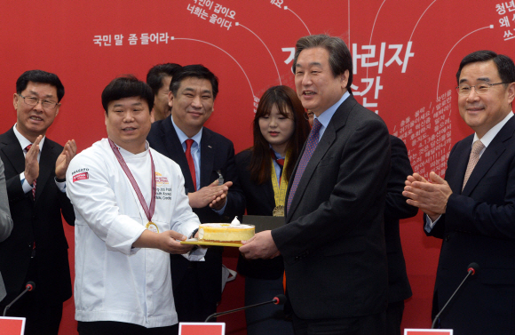 김무성 새누리당 대표가 2일 서울 여의도 국회에서 열린 소상공인과의 간담회에 앞서 세계제빵대회 우승자에게 케이크를 선물 받고 있다.  정연호 기자 tpgod@seoul.co.kr