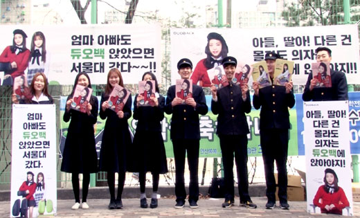 2일 오전 서울 송파구 잠신초등학교 정문 앞에서 교복을 입은 의자전문 브랜드 디비케이 모델들이 신입생에게 나눠줄 책받침을 들고 있다.