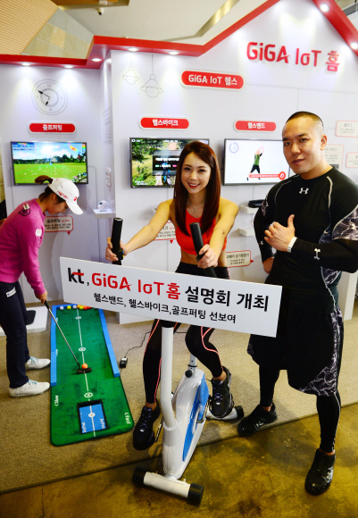 스포츠 트레이너 숀리(오른쪽)와 모델들이 3일 서울 세종로 올레스퀘어에서 KT의 사물인터넷(IoT) 홈 서비스인 ‘GIGA IoT 헬스밴드’와 헬스바이크, 골프퍼팅을 시연하고 있다. 박윤슬 기자 seul@seoul.co.kr