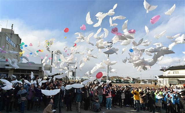 미야기현 나토리시의 한 학교에서 열린 동일본 대지진 4주년 기념식에서 참석자들이 평화를 상징하는 비둘기 형상의 풍선을 날리며 희생자들을 추모하고 있다. AFP 연합뉴스