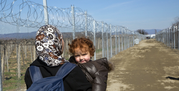 난민이 된 것이 죄인가요. 마케도니아 제브젤리야 난민 수용소에서 한 난민 여성이 5일(현지시간) 아이를 안고 가시가 박힌 삼엄한 철조망 사잇길을 걸어가고 있다. 그리스에 도착한 난민 대다수는 마케도니아 등 발칸 국가들을 지나 독일 등 서유럽에 정착하길 원한다. 하지만 오스트리아와 발칸지역 9개국이 지난달 말 국경 통제를 강화하기로 합의하면서 마케도니아와 인접한 그리스 난민촌은 심한 병목 현상을 보이고 있다. 난민들은 연일 마케도니아에 국경을 열어 달라고 요구하고 있지만 마케도니아 경찰은 최루탄과 섬광탄을 쏘며 이들을 막고 있다. 제브젤리야 AP 연합뉴스