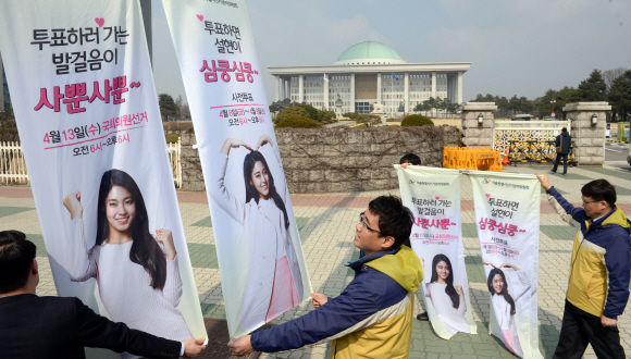 14일 서울 영등포구 여의도 국회 앞에서 서울시 선관위직원들이 선거를 독려하는 벽보를 붙이고 있다. 2016.3.14 박지환기자 popocar@seoul.co.kr
