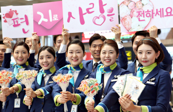 에어부산 승무원들이 화이트데이를 맞아 14일 김해국제공항 국내선 2층 출발장에서 방문객에게 사탕과 손편지 카드를 나눠주는 이벤트를 벌이고 있다.  2016.3.14  [에어부산 제공]