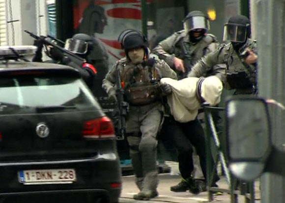 18일(현지시간) 벨기에 브뤼셀 외곽의 몰렌베이크에서 체포된 파리 테러의 주범 살라 압데슬람(가운데)이 경찰 특수부대에 끌려가고 있다. 압데슬람은 이날 경찰의 급습 과정에서 다리에 총상을 입었으며 간단한 조사를 받은 직후 서북부 브루제에 자리한 중범죄 교도소에 수감됐다. 브뤼셀 AP 연합뉴스