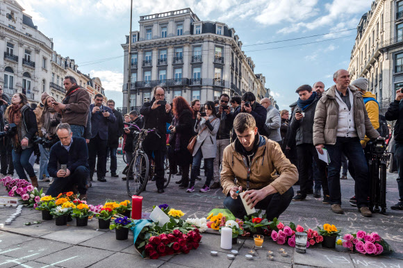 22일(현지시간) 벨기에 브뤼셀 증권거래소 앞에서 시민들이 촛불과 꽃다발로 테러 희생자들을 애도하고 있다. AP 연합뉴스