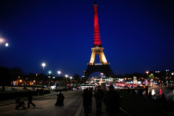 22일(현지시간) 프랑스 파리의 에펠탑이 벨기에 폭탄테러 희생자들에 대한 애도의 뜻으로 벨기에 국기색으로 불을 밝히고 있다. AP 연합뉴스