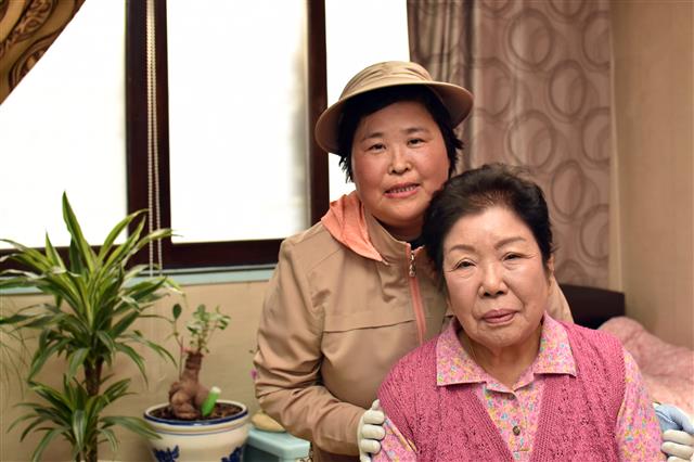 12년째 독거노인을 보살펴 온 양순례(왼쪽) 야쿠르트 아줌마가 경기 부천시 오정구 고강동에 거주하는 이순자 할머니와 기념사진을 찍고 있다. 한국야쿠르트 제공