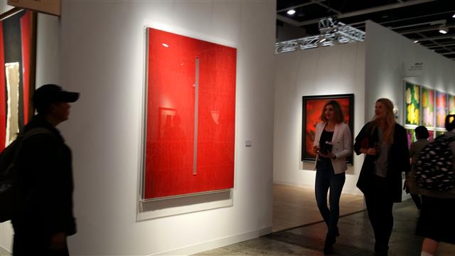 드 사르트 갤러리에서 출품한 박서보 화백의 작품 ‘묘법’ 앞을 관람객들이 지나가고 있다.