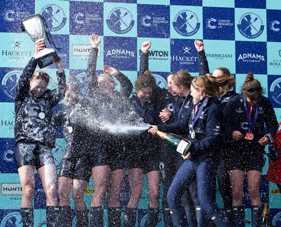 27일(현지시간) 영국 템스강에서 열린 옥스퍼드 대학과 케임브리지 대학의 여자 보트 경기에서 우승한 옥스퍼드 대학의 여학생들이 트로피를 들고 승리를 만끽하고 있다. AFP 연합뉴스