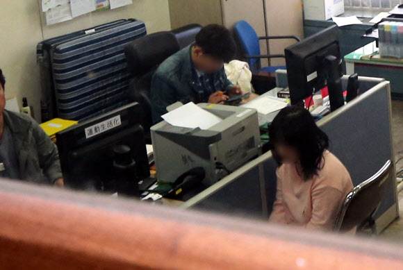 서울 관악경찰서 3층 사이버수사팀 복도 앞에서 한 여성이 염산을 살포해 경찰관이 부상한 4일 용의여성(오른쪽)이 강력반에서 조사를 받고 있다.  연합뉴스