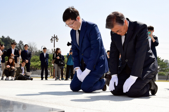 문재인 더불어민주당 전 대표와 김홍걸 더민주 국민통합위원장이 8일 오전 광주 국립 5·18 민주묘지를 찾아 무릎을 꿇고 참배하고 있다.  정연호 기자 tpgod@seoul.co.kr