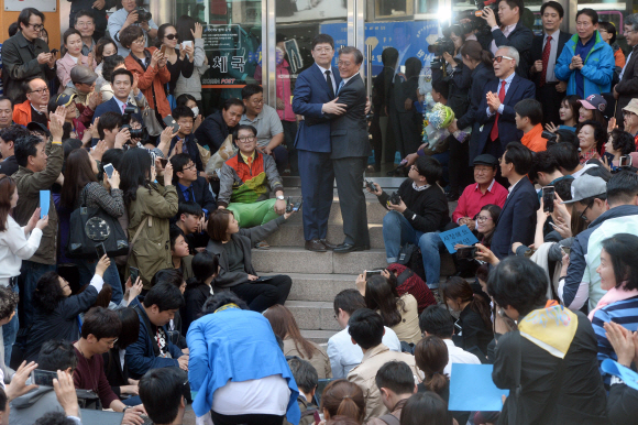 8일 광주 충장로우체국 앞에서 광주를 방문한 더불어민주당 문재인  전 대표와 김홍걸 국민통합위원장이 포옹을 하고 있다.  정연호 기자 tpgod@seoul.co.kr