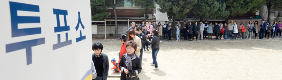 제20대 국회의원 선거일인 13일 서울 종로구 필운동 배화여자중학교에 마련된 청운효자동 제3투표소 앞에 시민들이 투표를 하기 위해서 길게 줄을 서서 기다리고 있다.  손형준 기자 boltagoo@seoul.co.kr