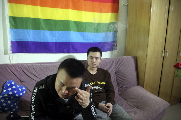 지난 12일 중국의 동성 커플인 쑨 원린(오른쪽)과 후 밍량이 그들의 집에 나란히 앉아 있다. 13일 중국 후난 성 창사 법원은 이들이 동성 간 결혼 증명서 발급을 거부한 시 공무원의 처분을 무효화시켜달라고 청구한 재판에서 원고의 요구를 기각했다. 중국 LGBT(성소수자) 권리 운동의 기념비적 사건이 된 이 재판을 보기 위해 수백명의 지지자들이 법원을 찾았