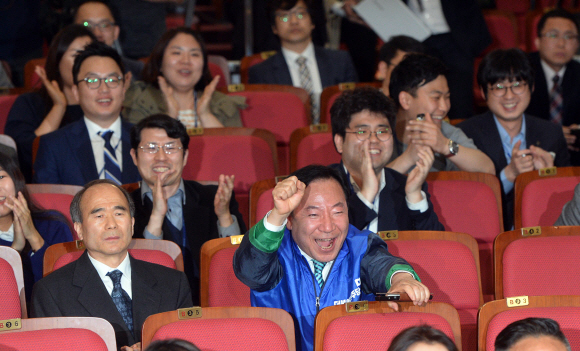 더불어민주당 김종인 비대위 대표가 지도부들과 13일 국회의원회관에서 방송사의 출구조사를 보며 박수를 치고 있다.   정연호 기자 tpgod@seoul.co.kr