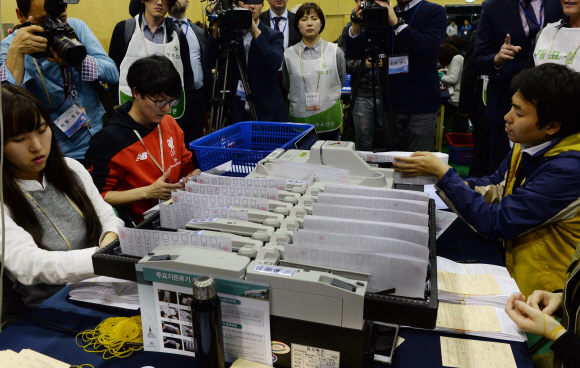 13일 저녁 종로구 청운동 경기상고에 마련된 개표소에서 투표용지를 분류하고 있는 자동계수기를 보고 있다.  강성남 선임기자 snk@seoul.co.kr