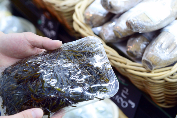 바텐더  우성현씨가 해산물코너에서 가니쉬(Garnish 요리 위에 곁들이는 장식, 식재료)로 사용될 톳을 고르고 있다.   정연호 기자 tpgod@seoul.co.kr