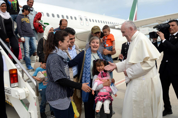 프란치스코 교황이 16일(현지시간) 로마 참피노 공항에 도착해 전용기에서 내리는 시리아 난민들을 따뜻하게 맞고 있다. 로마 EPA 연합뉴스