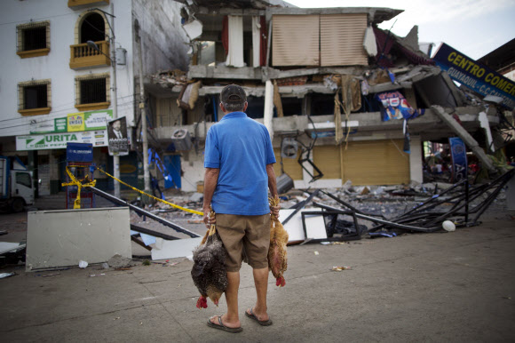 한 남성이 19일(현지시간) 에콰도르 만타에서 지진으로 무너져 내린 자신의 직장이었던 건물을 쳐다보고 있다. AP 연합뉴스