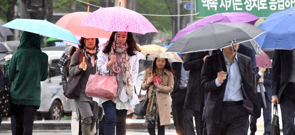 21일 서울 광화문네거리에서 우산을 쓴 시민들이 발걸음을 재촉하고 있다.  박윤슬 기자 seul@seoul.co.kr